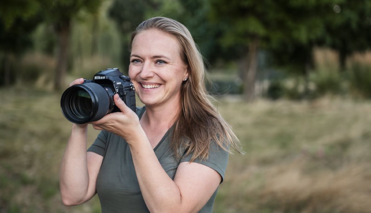 Rachel Konsella, a wedding photographer in Washington State, holding her camera