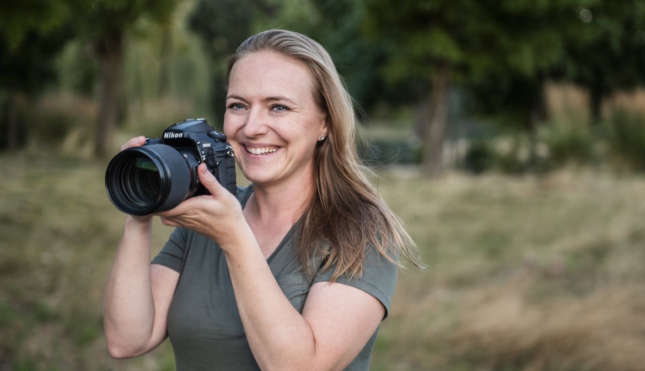 A female wedding photographer in Washington state holding her camera.
