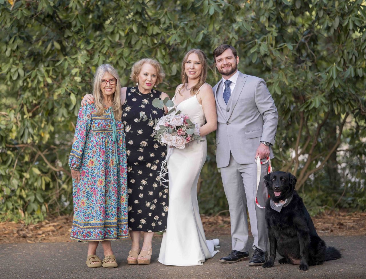 Bride and groom with family and black dog during outdoor wedding portraits in Camas Washington.
